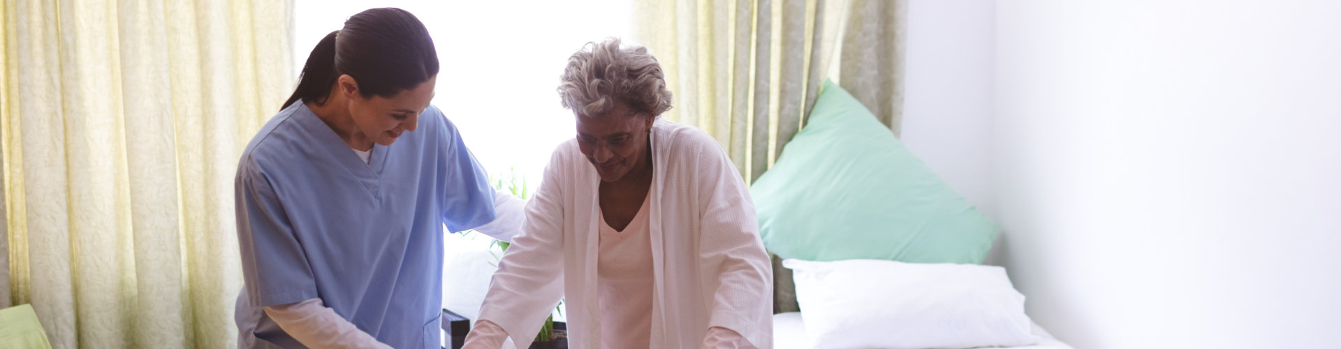 image of the healthcare staff helping senior woman to walk